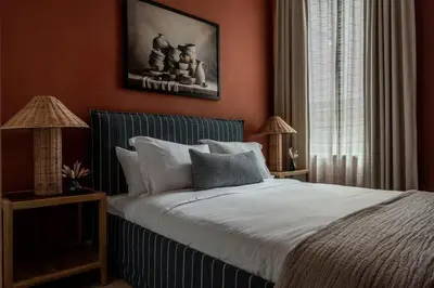 a bedroom with a bed with red walls and two lamps at Stylish Artisan Loft w Chic Design - The Potter in Philadelphia