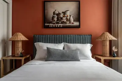 a bedroom with a bed with orange walls and two lamps at Stylish Artisan Loft w Chic Design - The Potter in Philadelphia