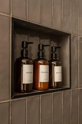 four bottles of soap are sitting on a shelf at The Artisan's Duplex - 8Bed -5Bath with 2 Car Parking in Philadelphia