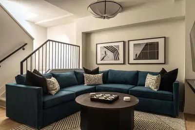 a living room with a blue couch and a table at The Artisan's Duplex - 8Bed -5Bath with 2 Car Parking in Philadelphia