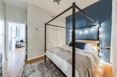 a bedroom with a canopy bed with a blue wall at Big & Bright 1BR - Center City - Walk Everywhere! in Philadelphia