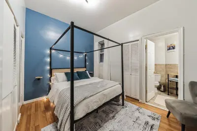 a bedroom with a canopy bed and a blue wall at Big & Bright 1BR - Center City - Walk Everywhere! in Philadelphia