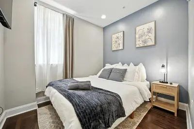 a bedroom with a large bed and a window at Center City - Modern 2 Bedroom in Philadelphia