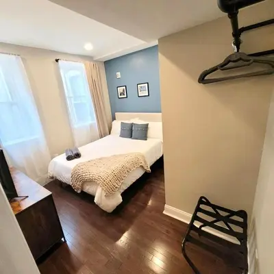 a bedroom with a bed with blue walls and wooden floors at Center City - Modern 2 Bedroom in Philadelphia