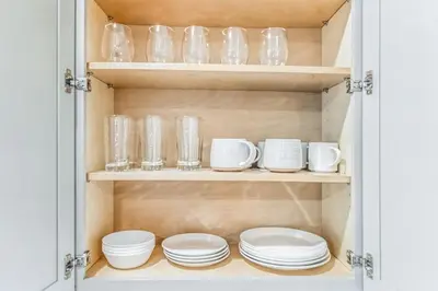 a cupboard filled with plates and glass dishes at Modern 2 bedroom - Center City in Philadelphia