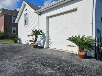 a white garage with two palm trees next to it at Old Charm Getaway in New Cumberland