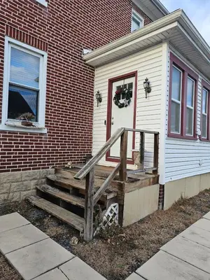a house with a wooden staircase leading to a door at Old Charm Getaway in New Cumberland