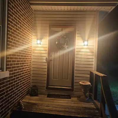 a white door with a wreath on it next to a brick wall at Old Charm Getaway in New Cumberland