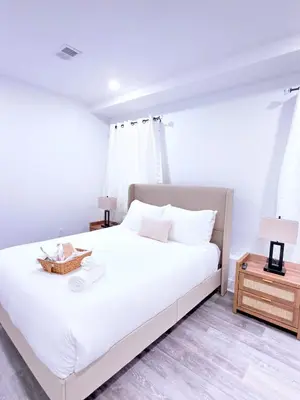 a bedroom with a large white bed and a night stand at Luxury Stay in Newark