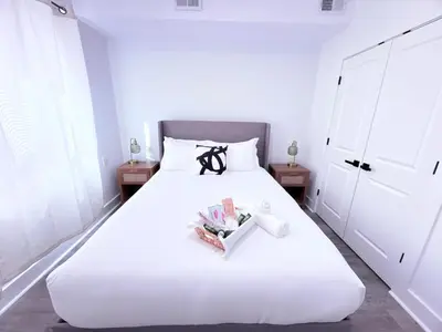 a white bed with a black bow on top of it at Luxury Stay in Newark