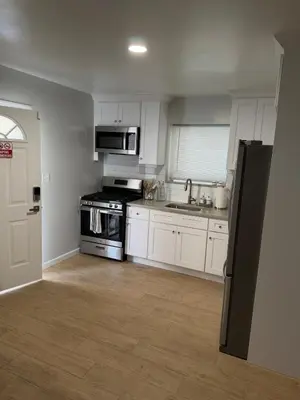 a kitchen with a stove and a sink and a refrigerator at Chic & Comfy Apartment