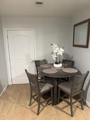 a black dining room table with chairs and a vase with flowers at Chic & Comfy Apartment