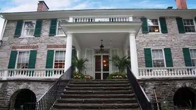 a large brick house with a staircase leading to the front door at Stocks Manor Bed and Breakfast in Mechanicsburg