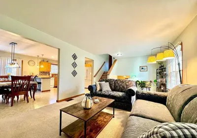 a living room with a couch and a table at Charming Family Friendly House, Hot tub, Playroom in Long Pond