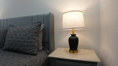 a lamp on a night stand next to a bed at Secluded Forest Escape with Game Room, Hot Tub and Fire Pit in Thornhurst