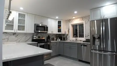 a kitchen with white cabinets and a stainless steel refrigerator at Secluded Forest Escape with Game Room, Hot Tub and Fire Pit in Thornhurst