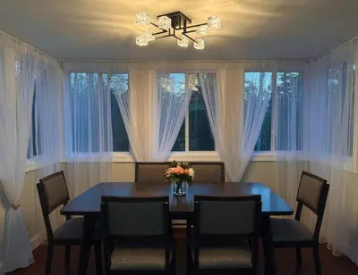 a dining room with a table and chairs and windows at Secluded Forest Escape with Game Room, Hot Tub and Fire Pit in Thornhurst