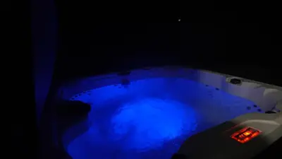 a blue hot tub in a dark room at Secluded Forest Escape with Game Room, Hot Tub and Fire Pit in Thornhurst