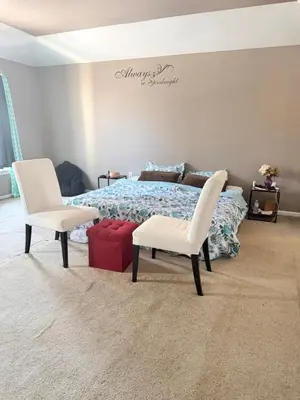 a bedroom with a bed and two white chairs at Poconos home away from home in East Stroudsburg
