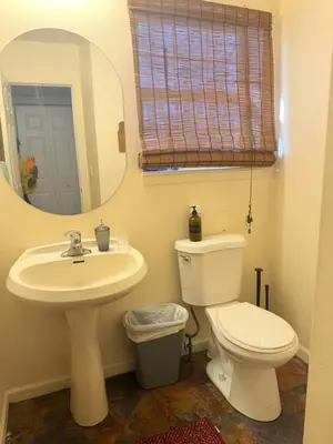 a bathroom with a toilet and a sink and a mirror at Poconos home away from home in East Stroudsburg