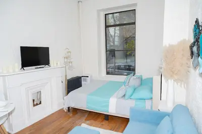 a white bedroom with a bed and a tv at Stylish2 Upper West Side Apartment 5-Min Walk to Central Park in New York