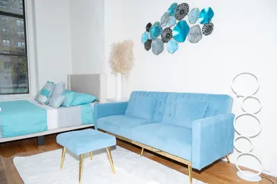 a living room with a blue couch and a chair at Stylish2 Upper West Side Apartment 5-Min Walk to Central Park in New York