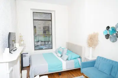 a bedroom with a bed and a couch and a window at Stylish2 Upper West Side Apartment 5-Min Walk to Central Park in New York