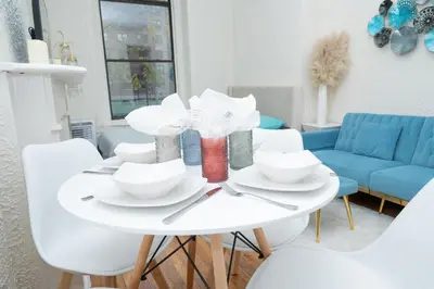 a white table with plates and bowls on it at Stylish2 Upper West Side Apartment 5-Min Walk to Central Park in New York