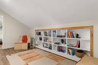 a room with white book shelves filled with books at Cozy Creekside Retreat - Minutes to Delhi & Andes in De Lancey