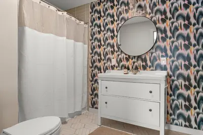 a bathroom with a toilet and a sink and a mirror at Cozy Creekside Retreat - Minutes to Delhi & Andes in De Lancey