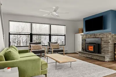 a living room with a green couch and a fireplace at Cozy Creekside Retreat - Minutes to Delhi & Andes in De Lancey