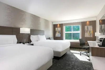 a hotel room with two beds and a desk at Courtyard by Marriott Edgewater NYC Area in Edgewater