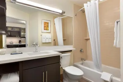 a bathroom with a sink and a toilet and a tub at Candlewood Suites Vestal - Binghamton by IHG in Vestal