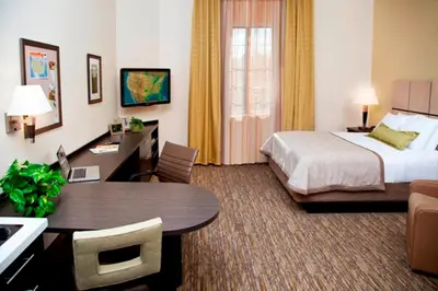 a hotel room with a bed and a desk at Candlewood Suites Vestal - Binghamton by IHG in Vestal