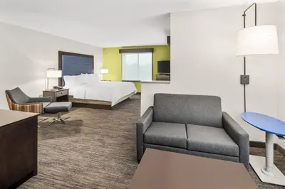 a hotel room with a bed and a couch at Holiday Inn Express & Suites Wilmington-Newark by IHG in Newark