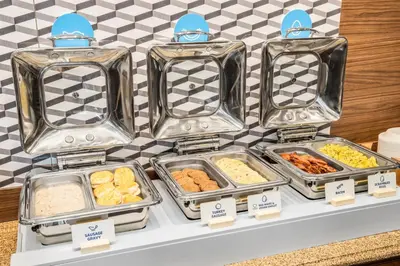 a display of food in trays on a shelf at Holiday Inn Express & Suites Wilmington-Newark by IHG in Newark