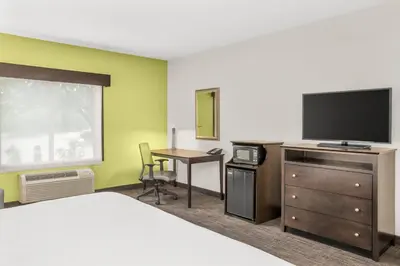 a hotel room with a bed and a desk with a television at Holiday Inn Express & Suites Wilmington-Newark by IHG in Newark