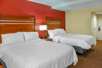 two beds in a hotel room with red walls at Holiday Inn Express Harrisburg SW - Mechanicsburg by IHG in Mechanicsburg