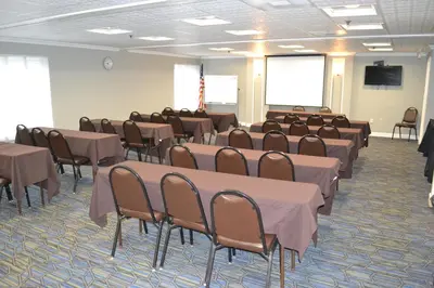 a conference room with tables and chairs and a screen at Holiday Inn Express Harrisburg SW - Mechanicsburg by IHG in Mechanicsburg