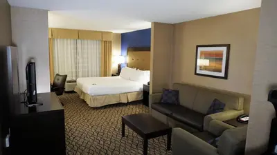 a hotel room with a bed and a couch at Holiday Inn Express & Suites Gibson by IHG in New Milford