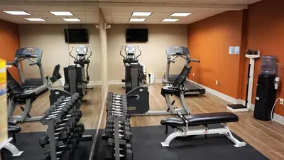 a gym with several tread machines in a room at Holiday Inn Express & Suites Gibson by IHG in New Milford