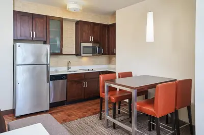 a kitchen with a table and a refrigerator at Residence Inn by Marriott Philadelphia Airport in Philadelphia