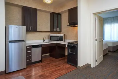a kitchen with a stainless steel refrigerator and cabinets at Residence Inn by Marriott Philadelphia Airport in Philadelphia