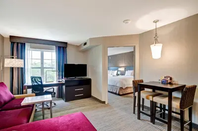 a hotel room with a bed and a living room at Residence Inn by Marriott Hamilton in Hamilton