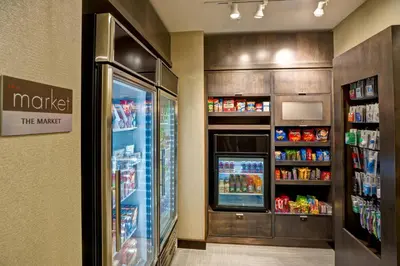 a grocery store aisle with a refrigerator and drinks at Residence Inn by Marriott Hamilton in Hamilton