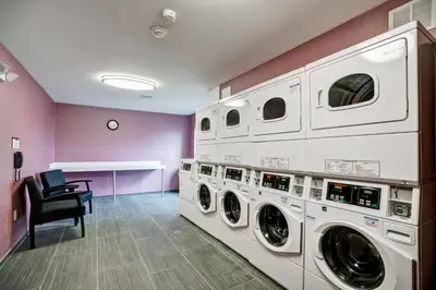 a laundry room with three washer and dryer machines at Residence Inn by Marriott Hamilton in Hamilton