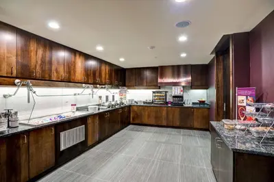 a large kitchen with wooden cabinets and counters at Residence Inn by Marriott Hamilton in Hamilton