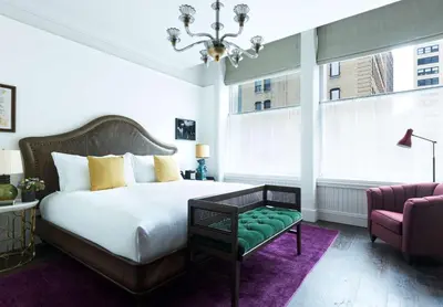 a bedroom with a bed and a couch and a chair at The Beekman, A Thompson Hotel, by Hyatt in New York