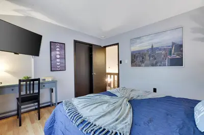 a bedroom with a bed with a blue comforter and a desk at Chalet renovated Near Casino, Camelback , Kalahari 4bdrms firepit hot tub game room in Tobyhanna