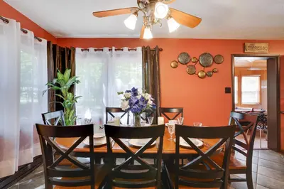 a dining room with orange walls and a table with chairs at Chalet renovated Near Casino, Camelback , Kalahari 4bdrms firepit hot tub game room in Tobyhanna